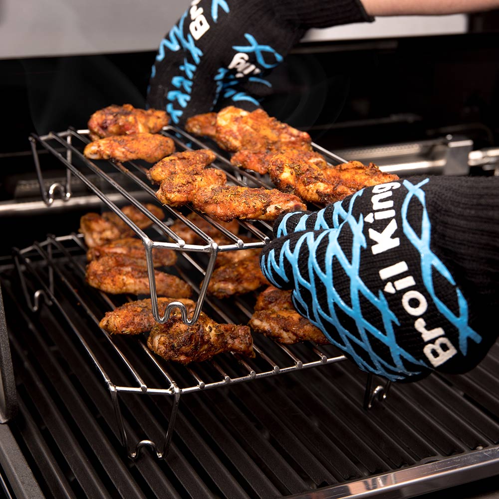 Stainless steel rack with several browned meat pieces on the grill grates