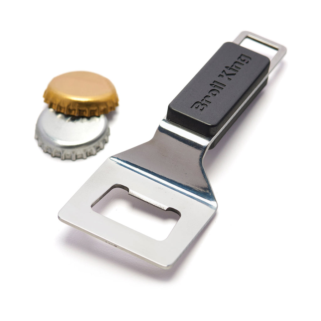 Stainless steel bottle opener with black grip, next to a gold bottle cap