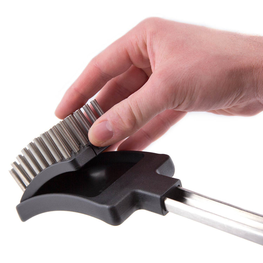 Hand holding a grill brush with coil spring bristles and metal handle
