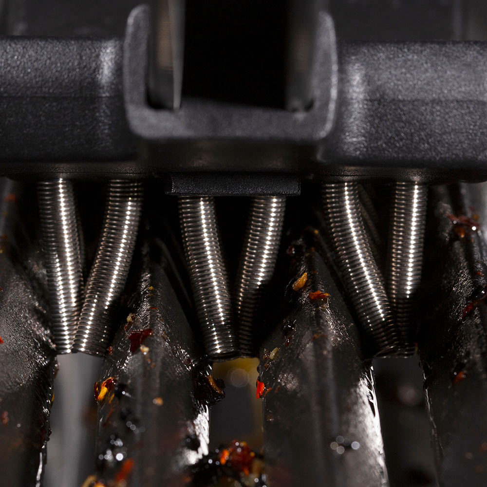 Close-up of coil spring bristles on a grill brush, set into grill grates