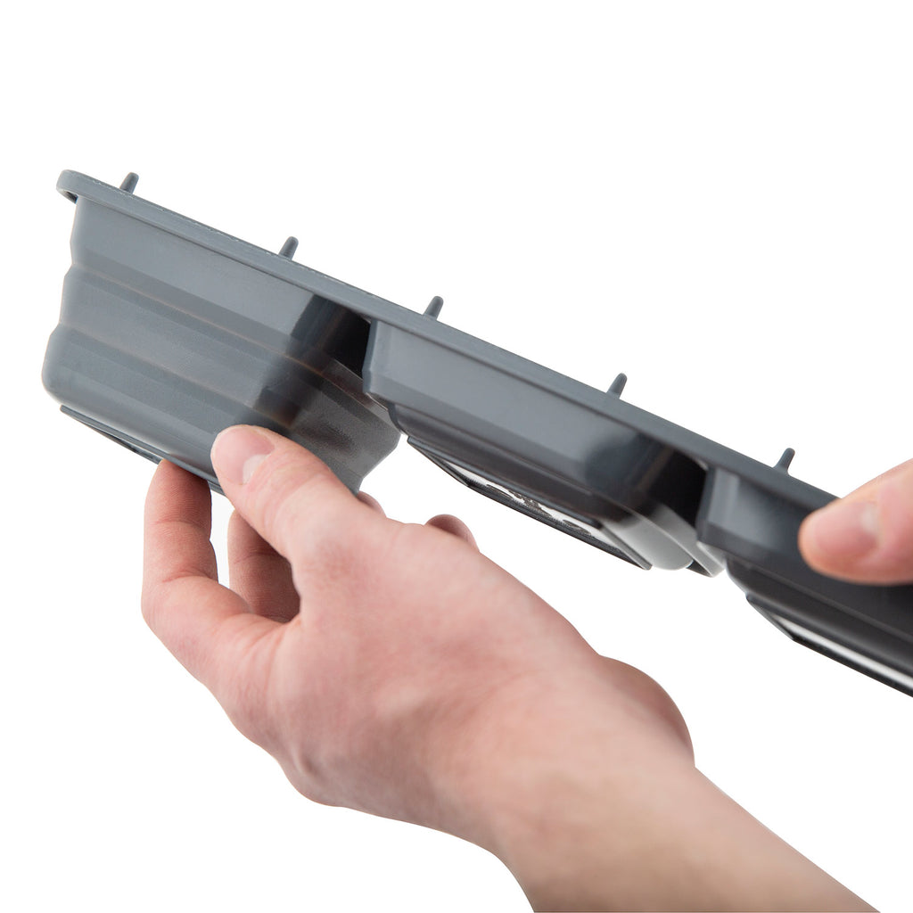 Ice grill brush refill tray with gray insert compartments, held by fingers