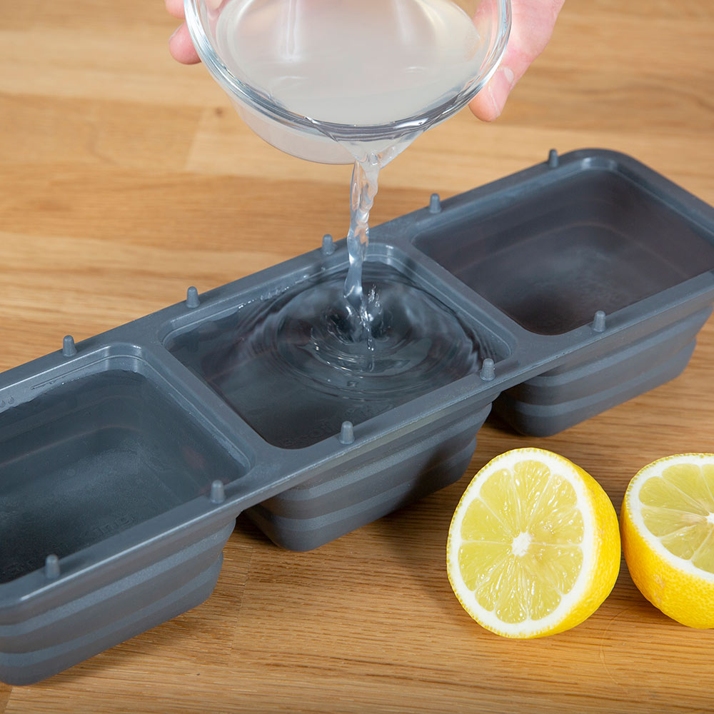 Ice grill brush tray with melting ice water poured into gray compartments
