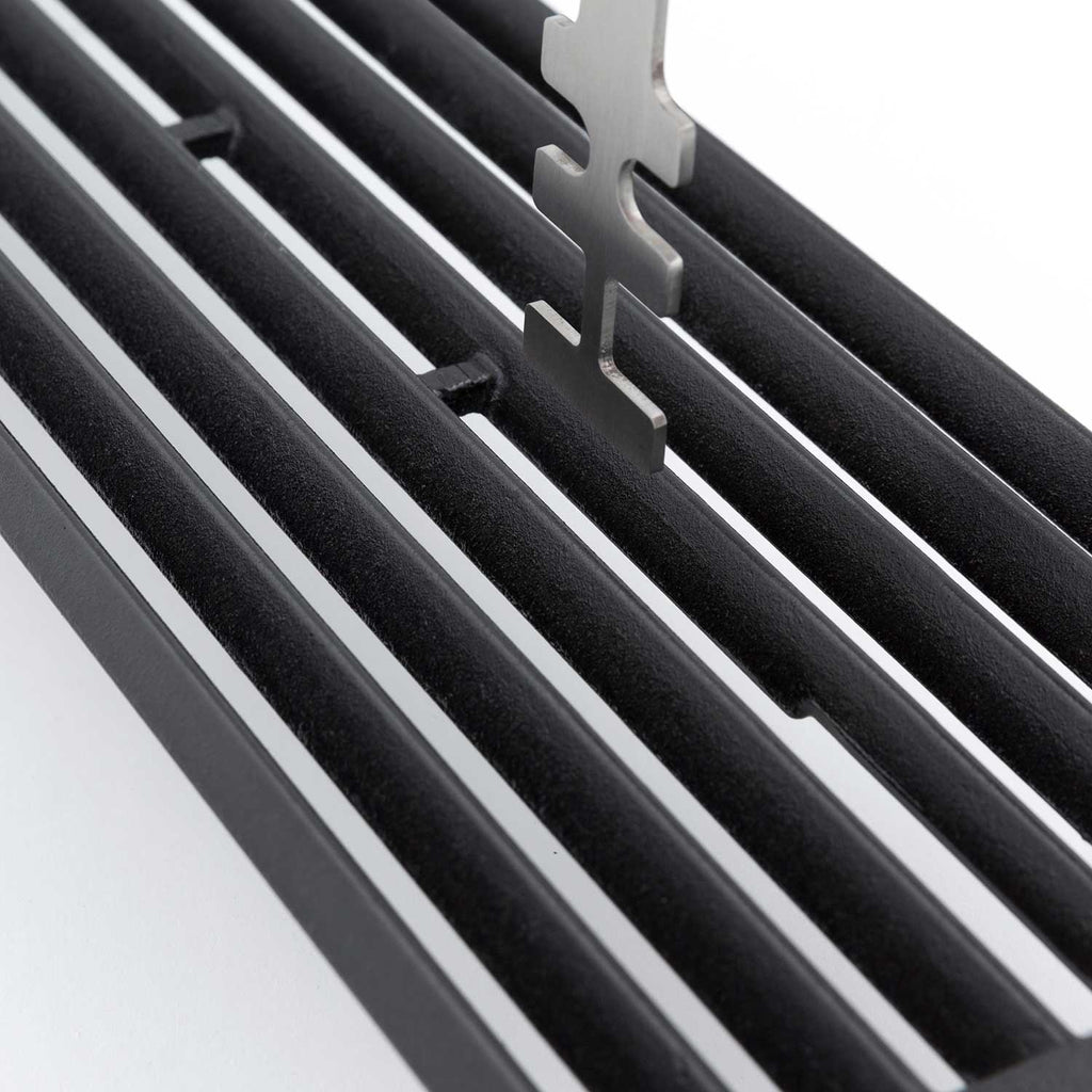 Broil King grid lifter with metal prongs fitted on black grill grates
