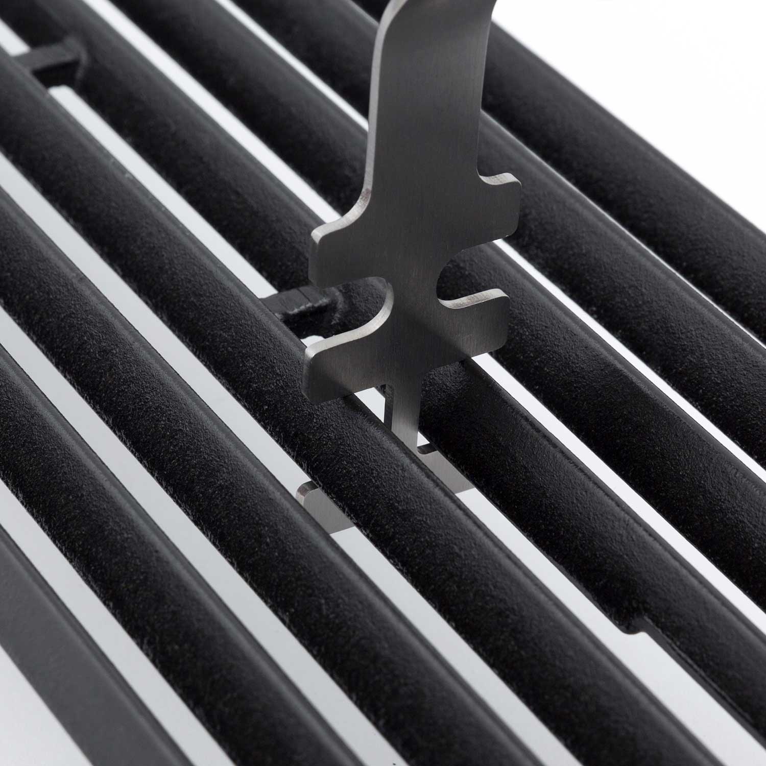 Broil King grid lifter close-up with metal prongs on black grill grates