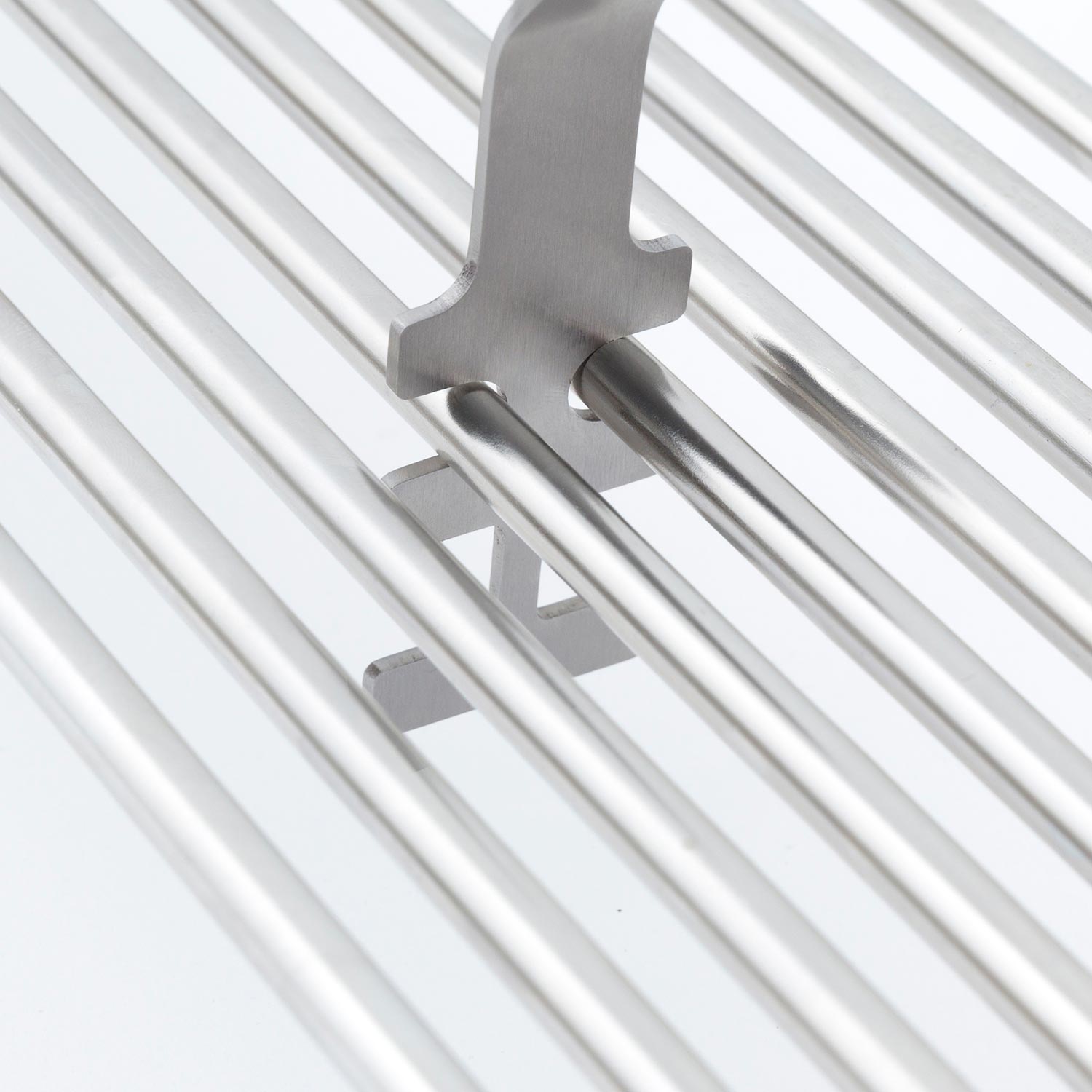 Broil King grid lifter close-up with metal prongs on silver grill grates