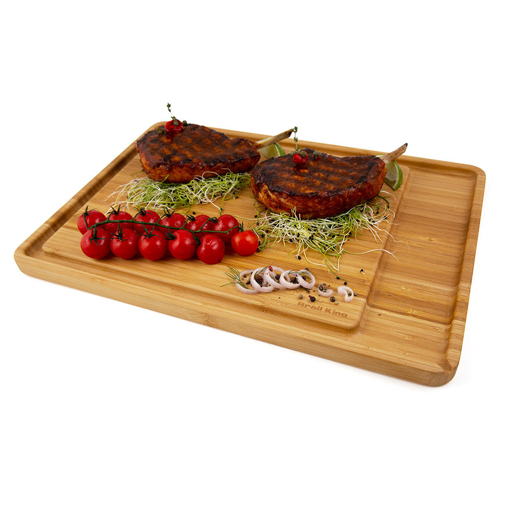 Bamboo cutting and serving board with grilled patties, cherry tomatoes, and herbs