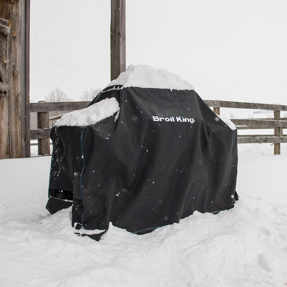 Broil King grill cover, dark polyester with logo, dusted with snow