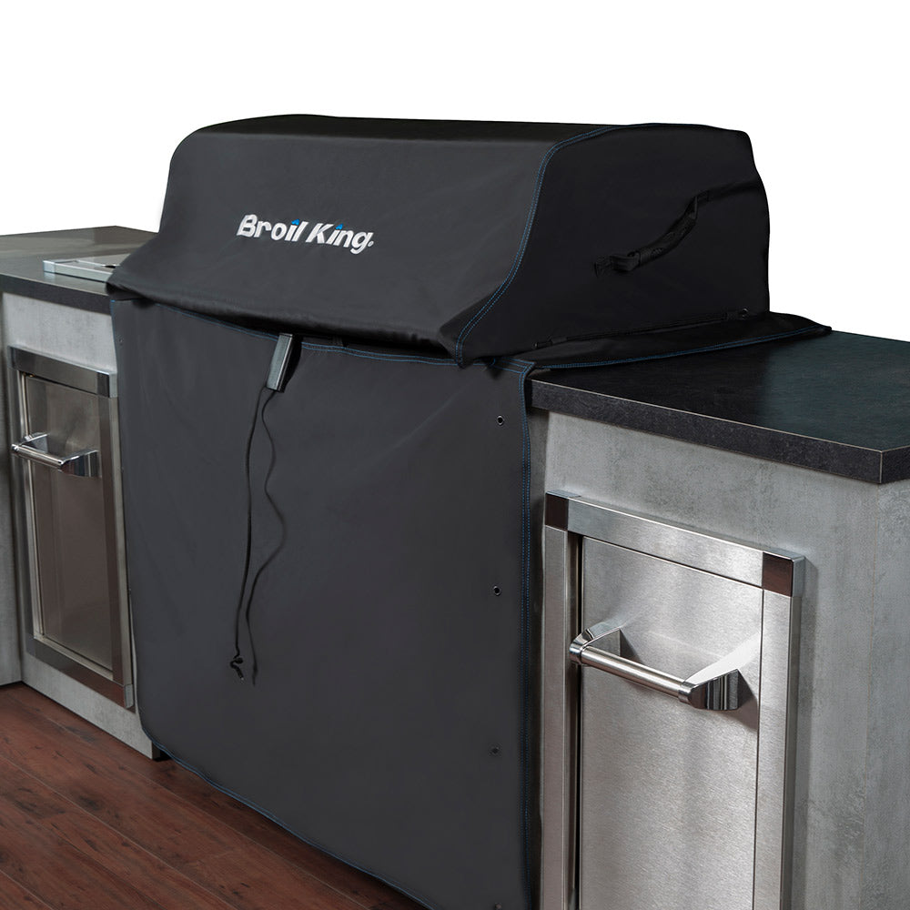 Black grill cover with Broil King logo, draped over the side of a gas grill