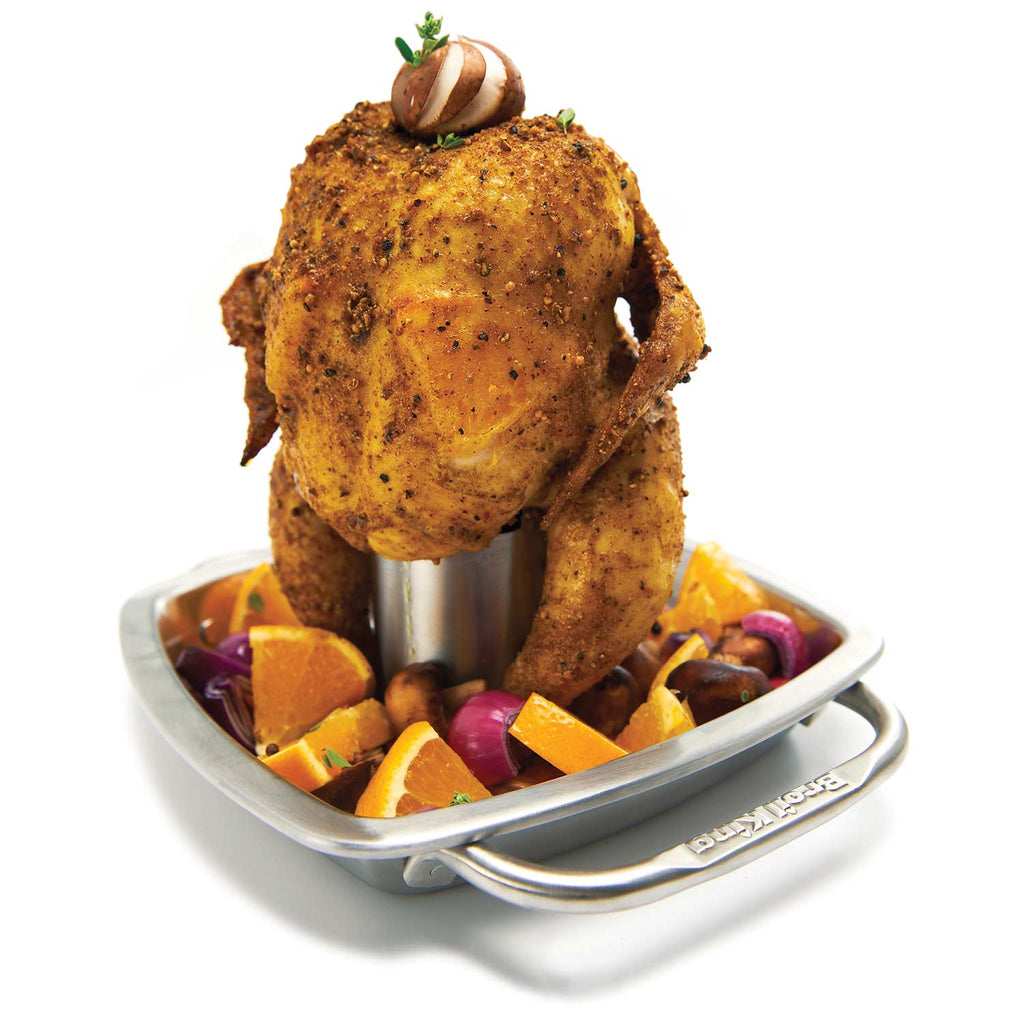 Stainless steel chicken roaster with pan, holding roasted chicken and vegetables