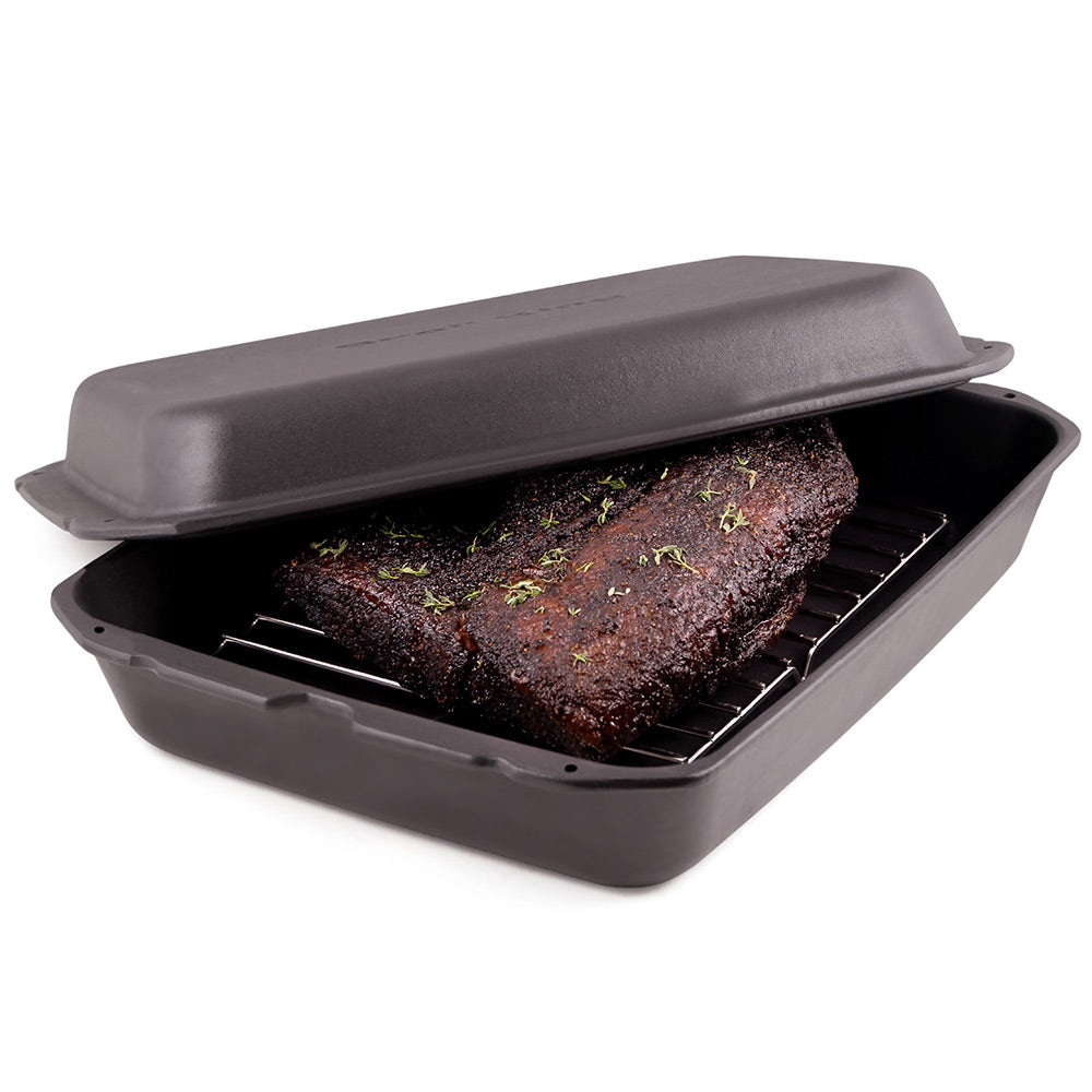 Broil King cast iron multi roaster with lid open, showing seasoned roast on rack