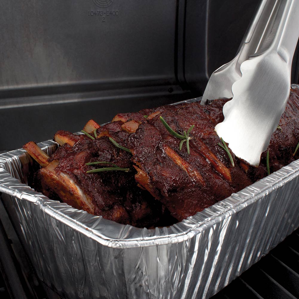 Foil roaster liner with cooked ribs and serving spatula