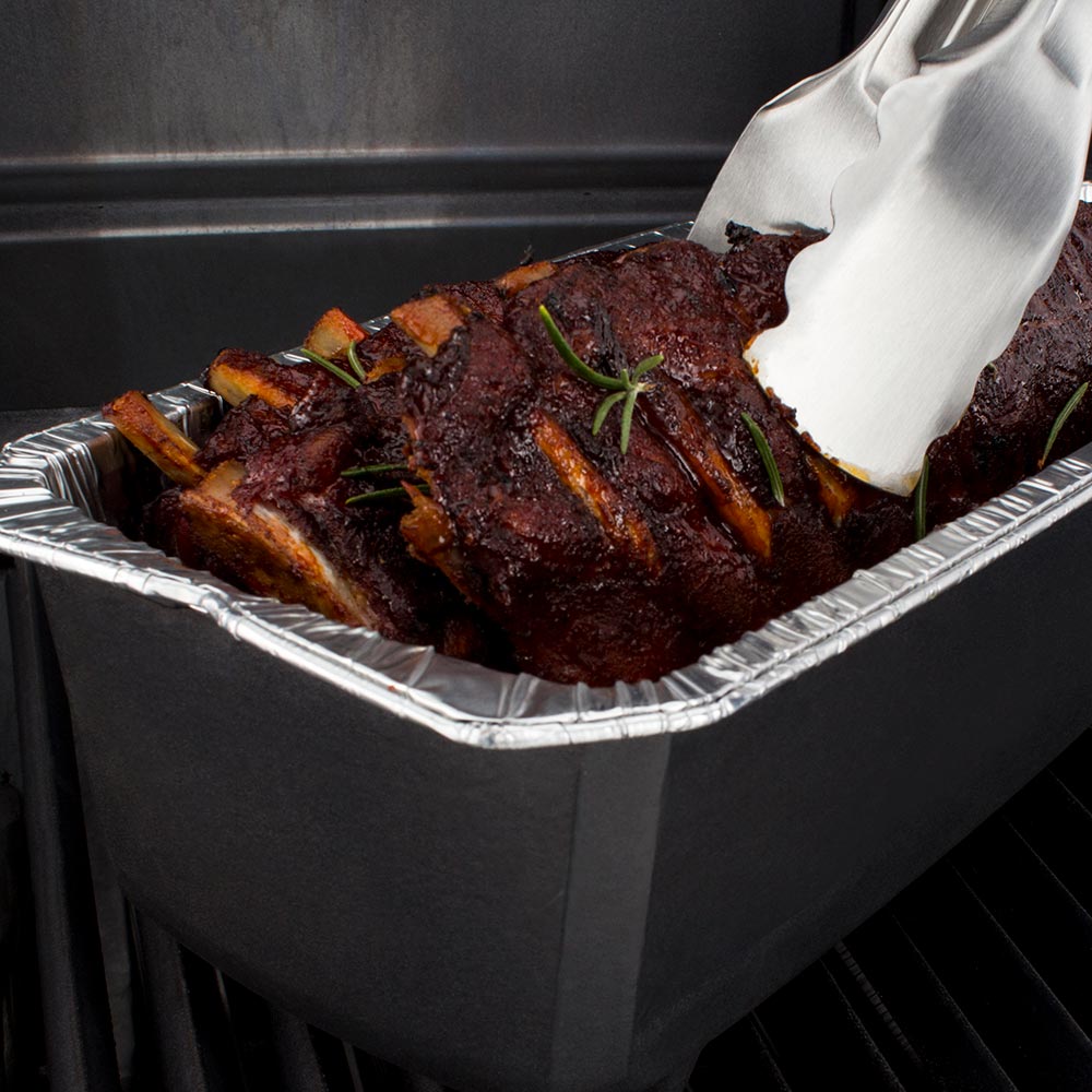 Foil roaster liner holding ribs, with spatula resting on top