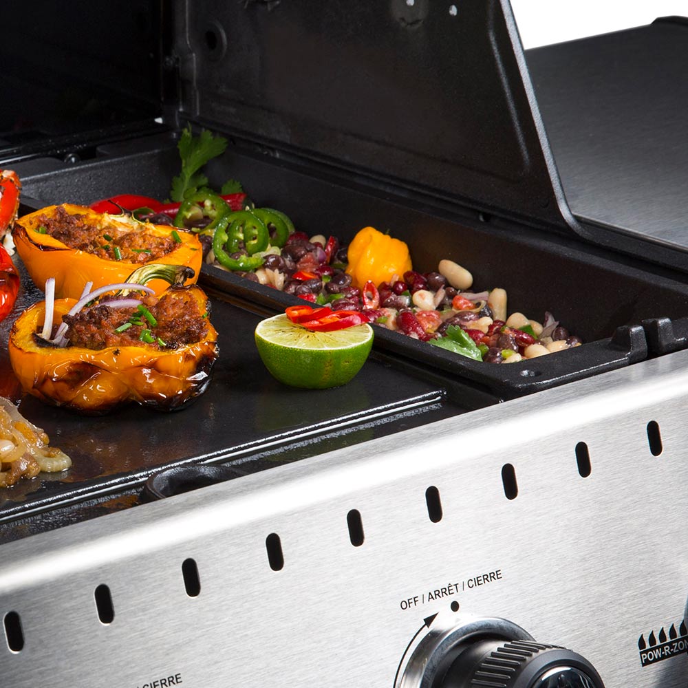 Cast iron wok insert on grill with grilled chicken, peppers, and chopped vegetables