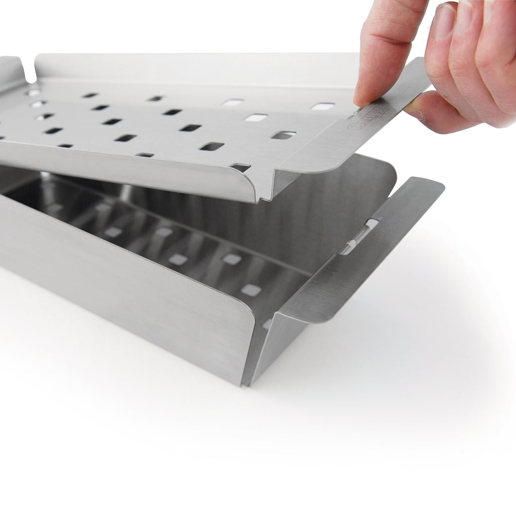 Stainless steel grill topper grate with vent holes, hands adjusting