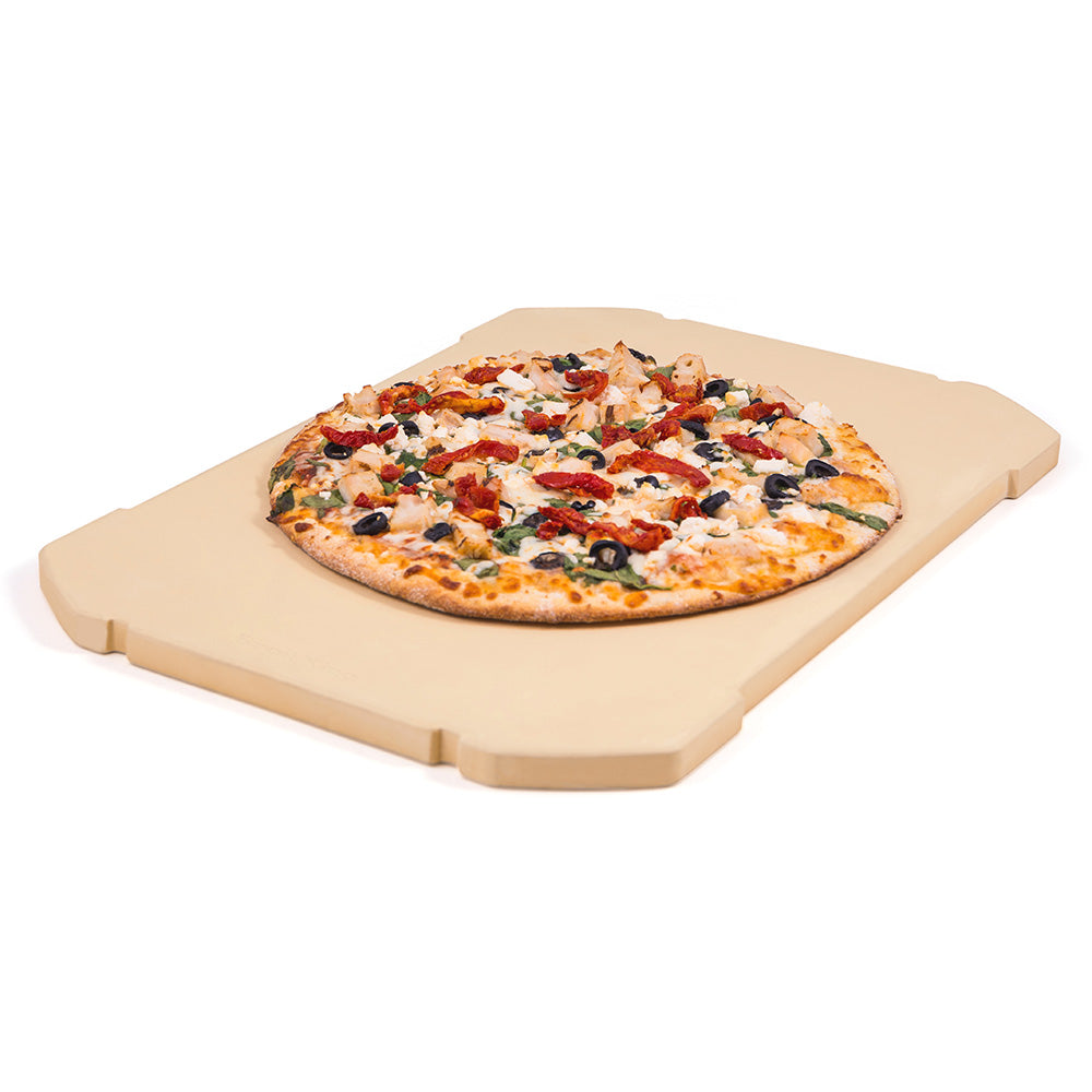 Rectangular pizza stone with beige surface and corner handles, with pizza on top