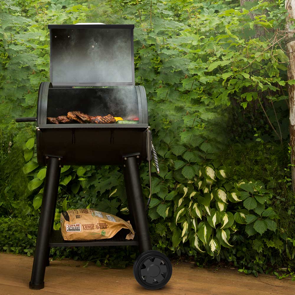 Broil King charcoal smoker grill with open lid, cooking chamber, and charcoal bag shelf