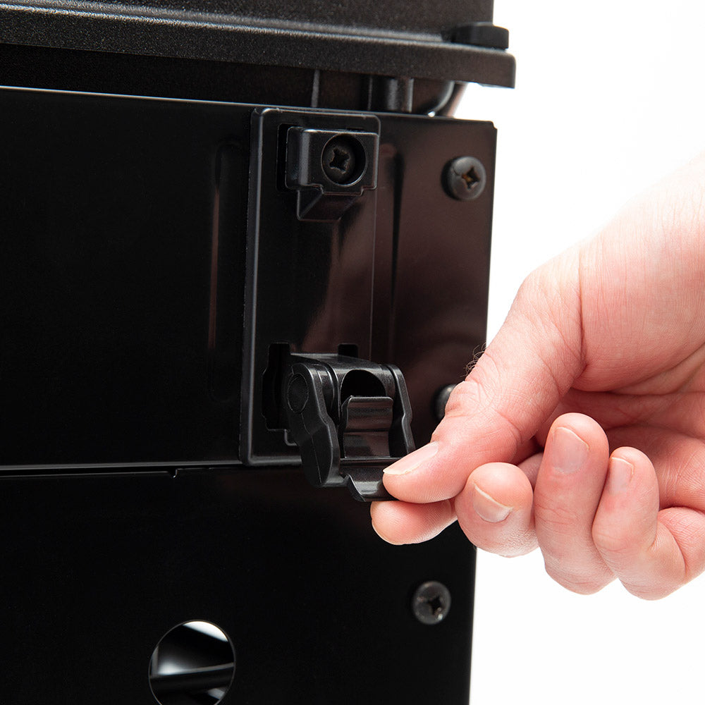 Gas grill igniter control area with hand adjusting a knob on the front panel