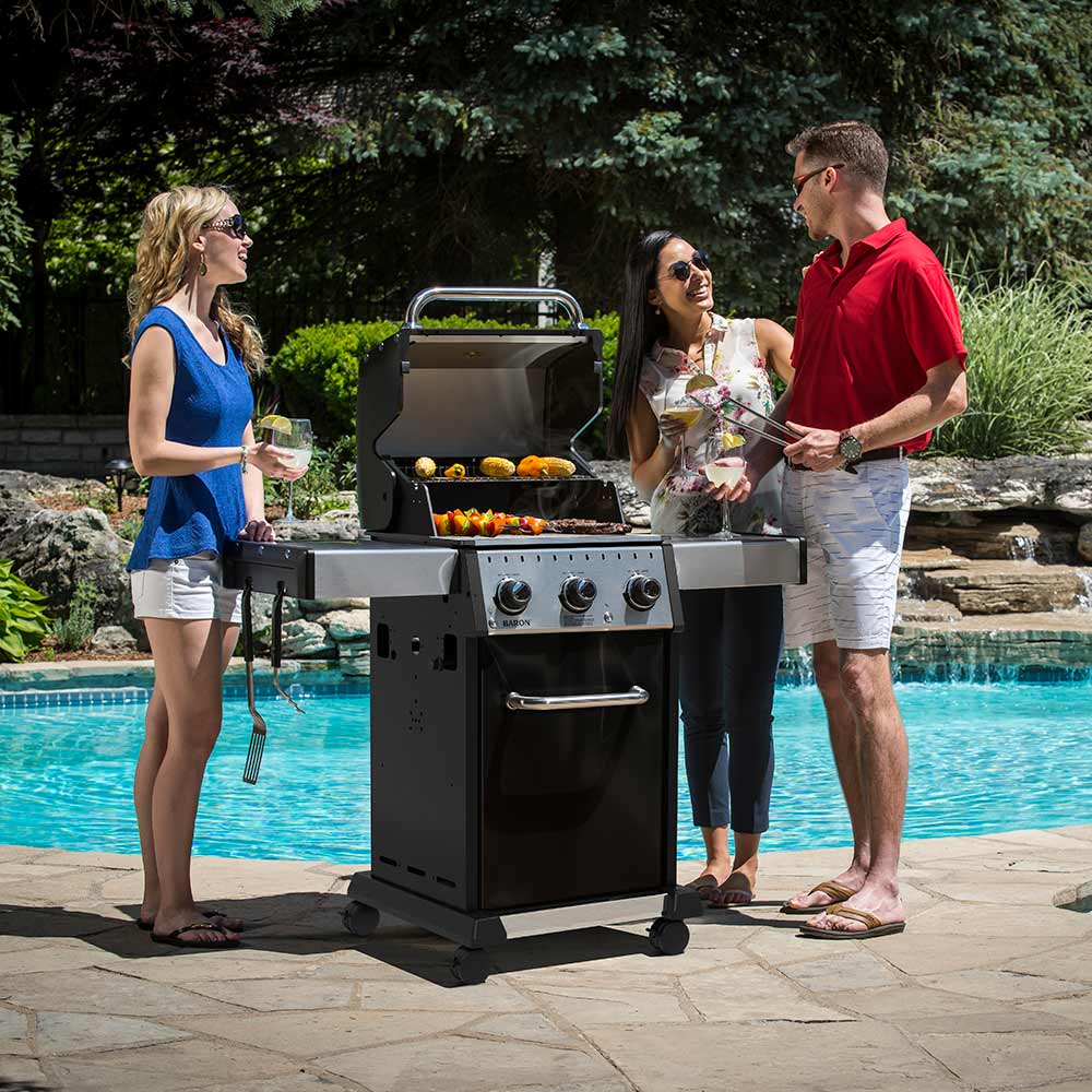 3-burner gas grill with open lid and cooking grates holding food