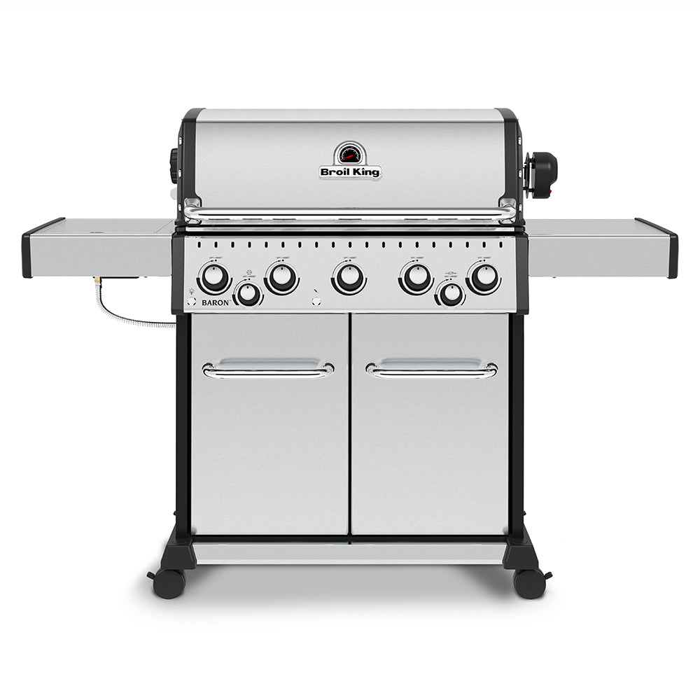 Stainless steel gas grill with lid, control knobs, and side shelf