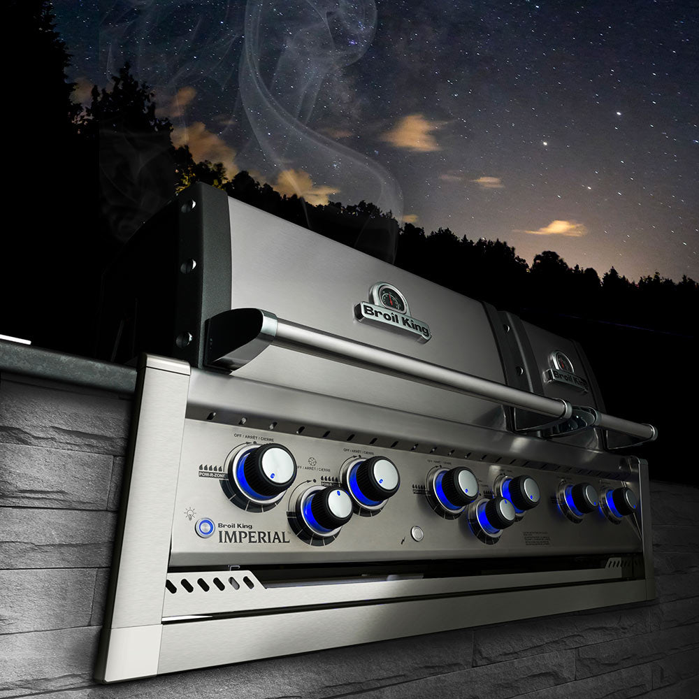 Broil King Imperial gas grill with blue-lit burner control knobs and lid