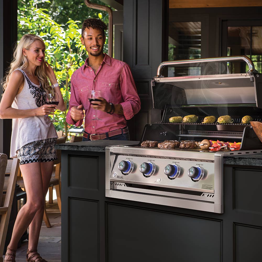 Stainless steel 4-burner built-in gas grill head with open lid, food cooking inside