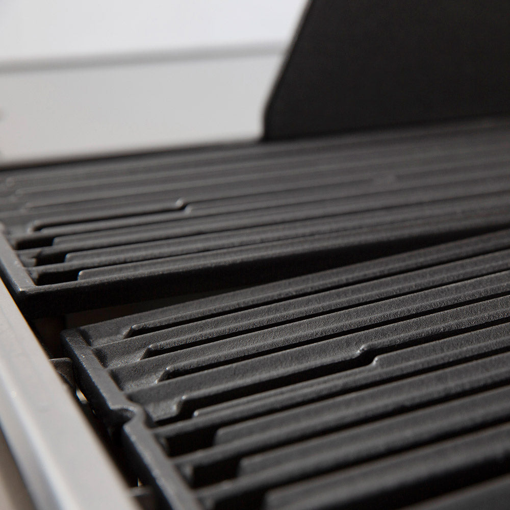 Gas grill cast grates with parallel slots and dark cooking surface