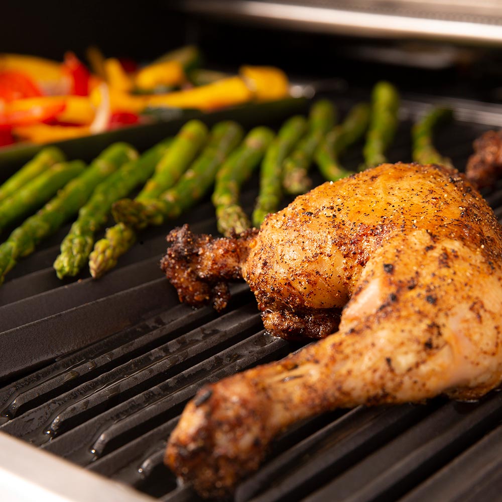 Gas grill grate with browned chicken and green peppers