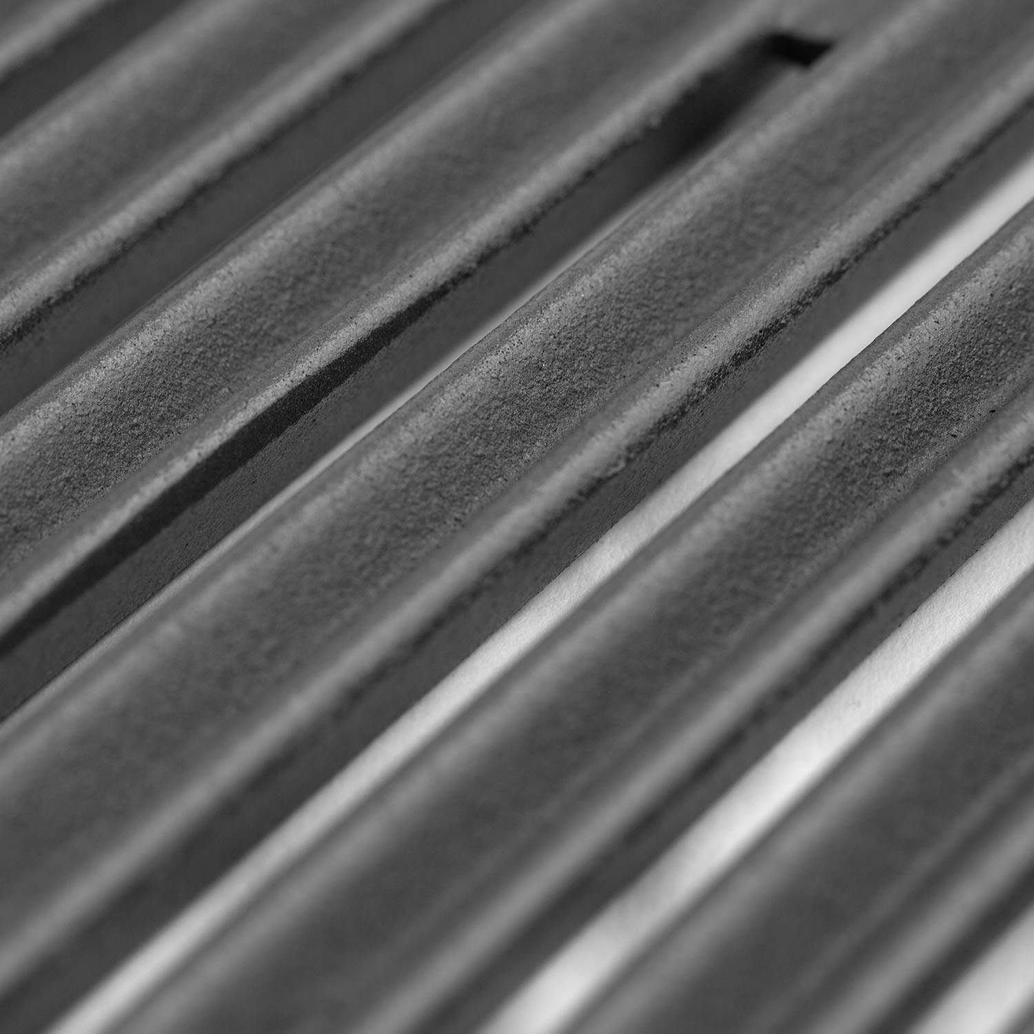 Close-up of gas burner tubes with blue ignition flames