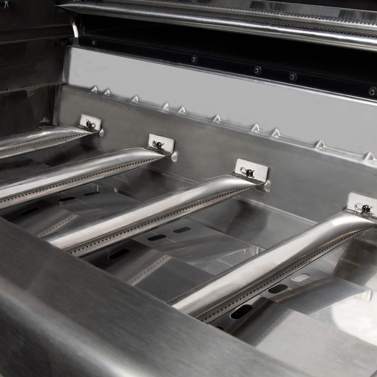 Open grill firebox with metal grates and burner guards
