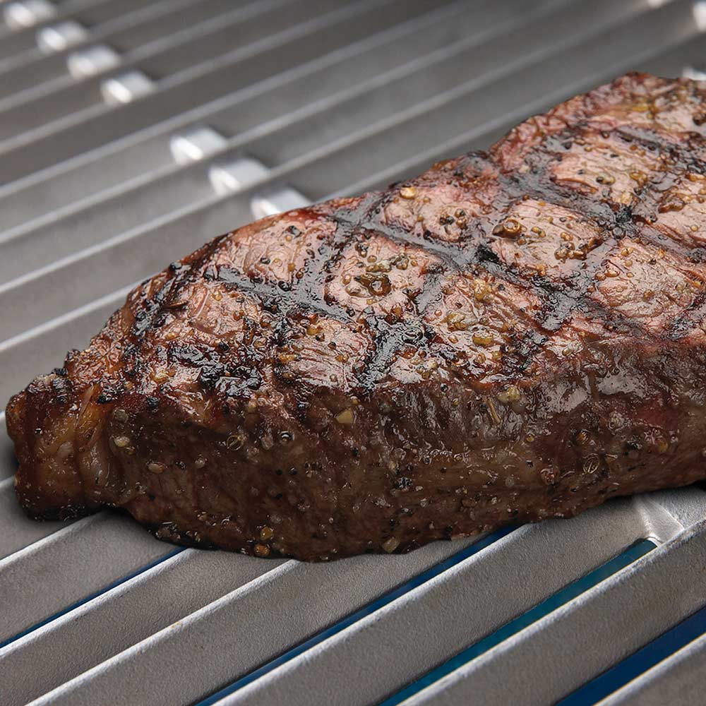 Grilled steak on stainless steel grill grate
