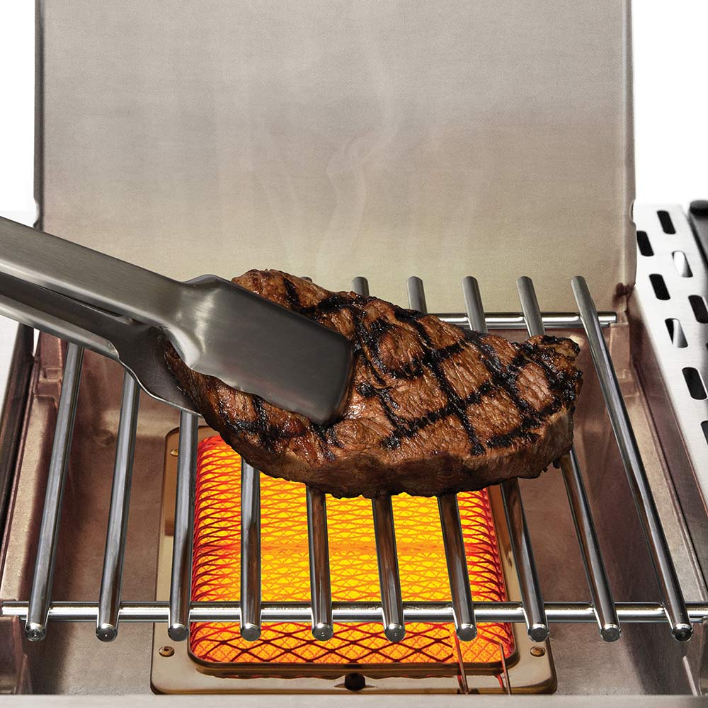 Grill burner with a browned meat skewer on the grate above heat shield