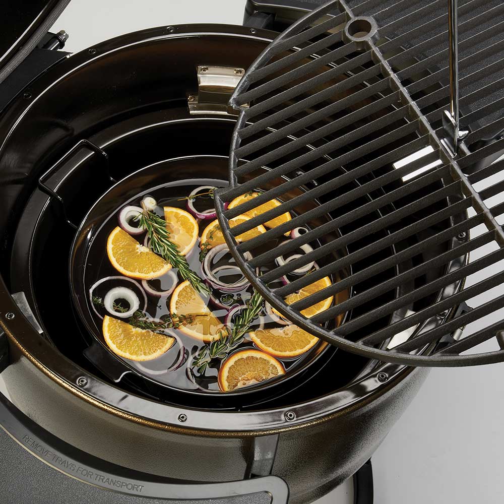 Black slotted diffuser grate over food in a keg grill