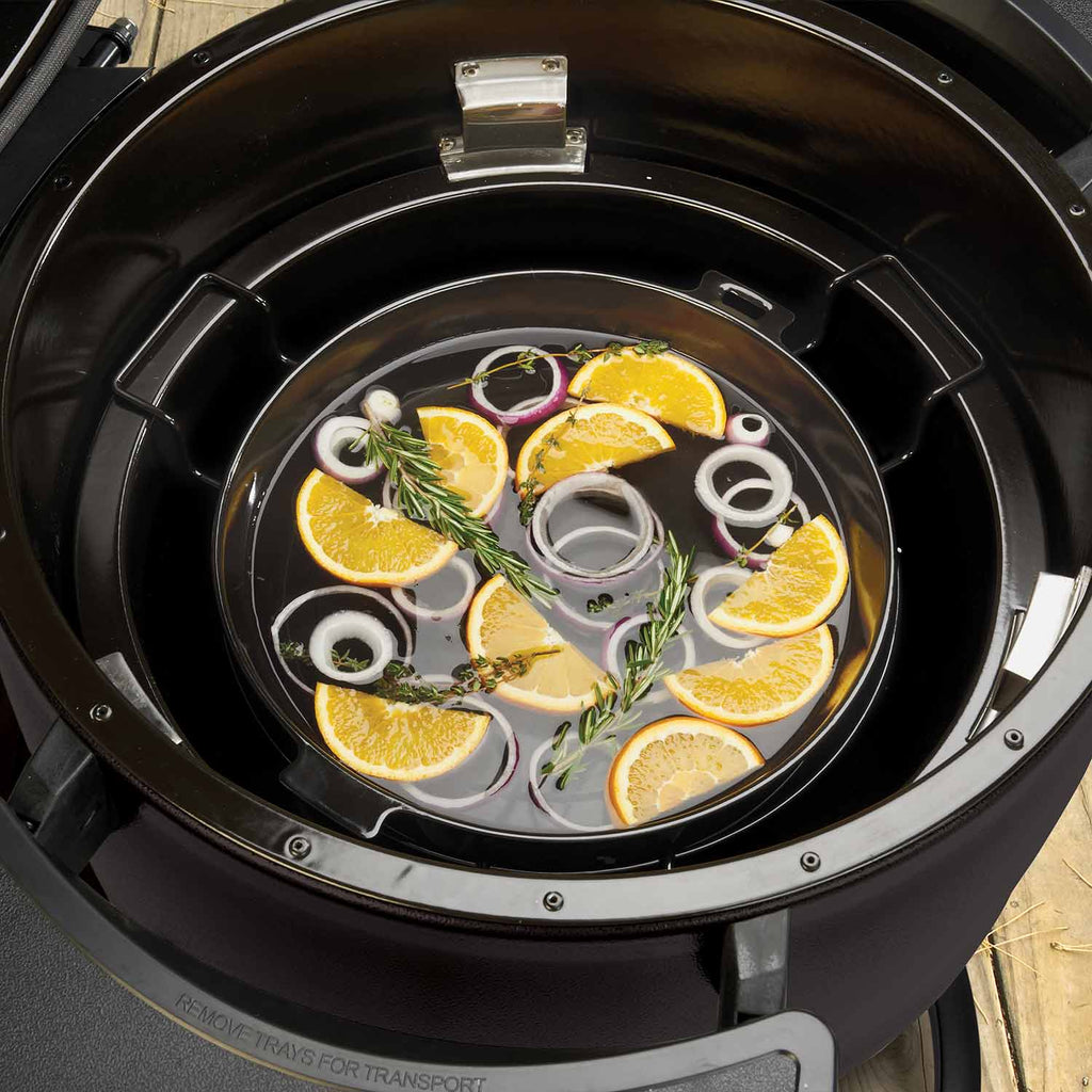 Black slotted diffuser kit in a keg grill with citrus and herb garnish