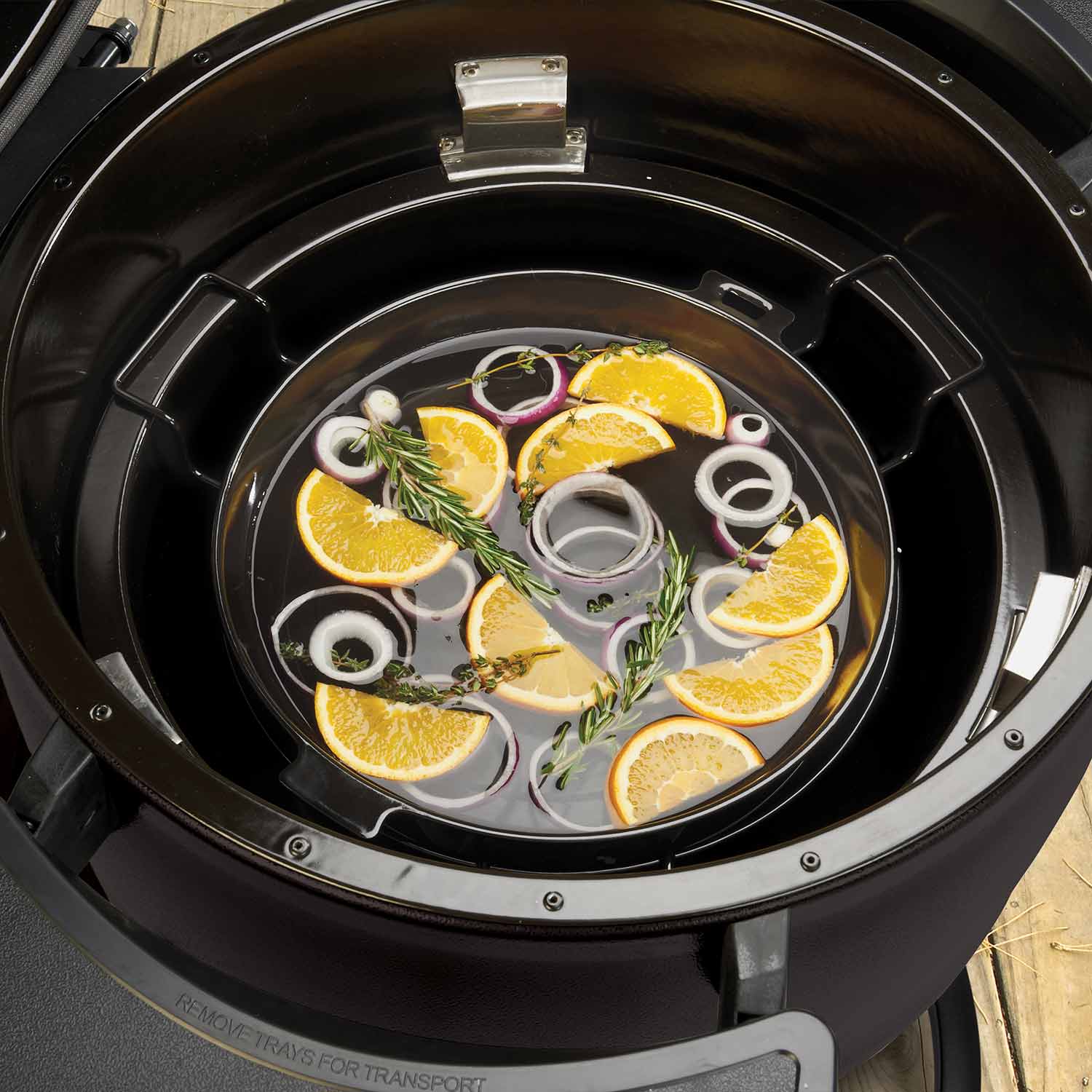 Black slotted diffuser kit in a keg grill with citrus and herb garnish