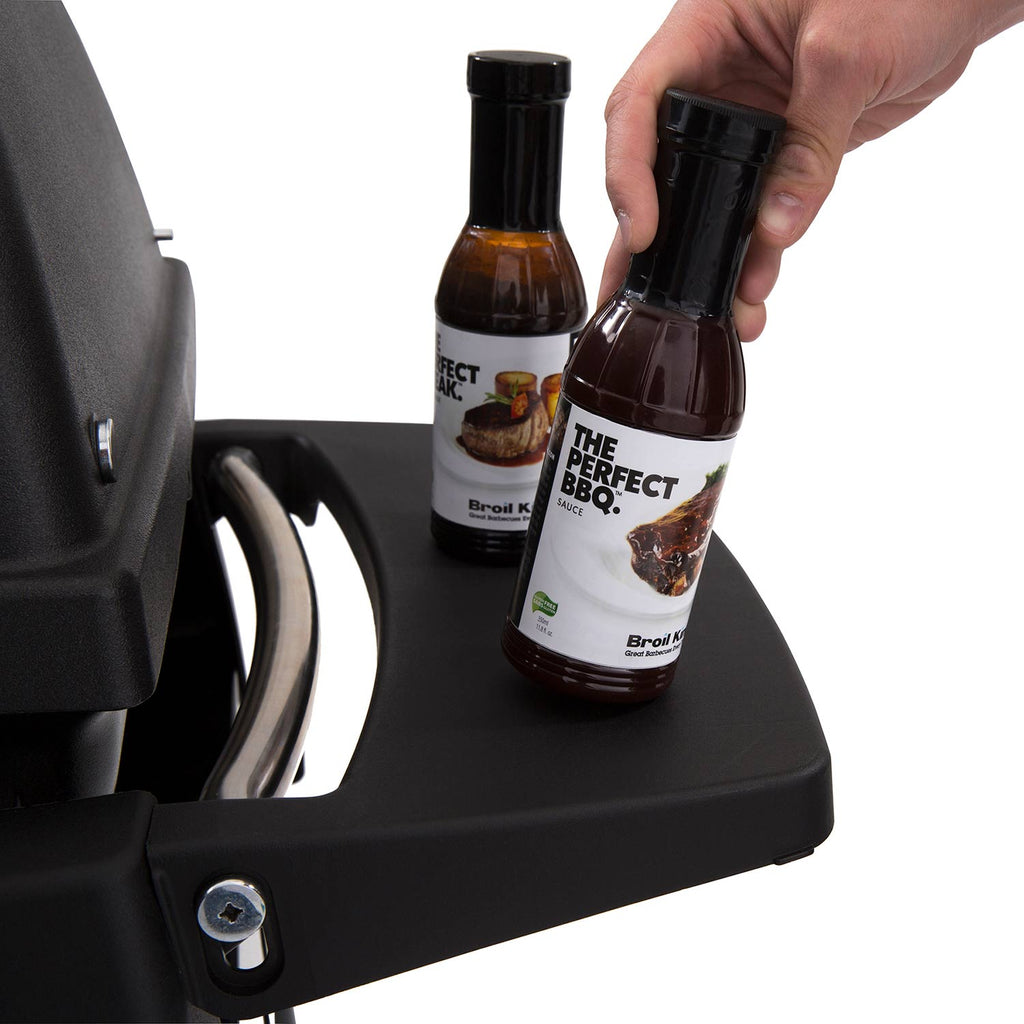 Portable propane grill side shelf with condiment bottles next to the control area