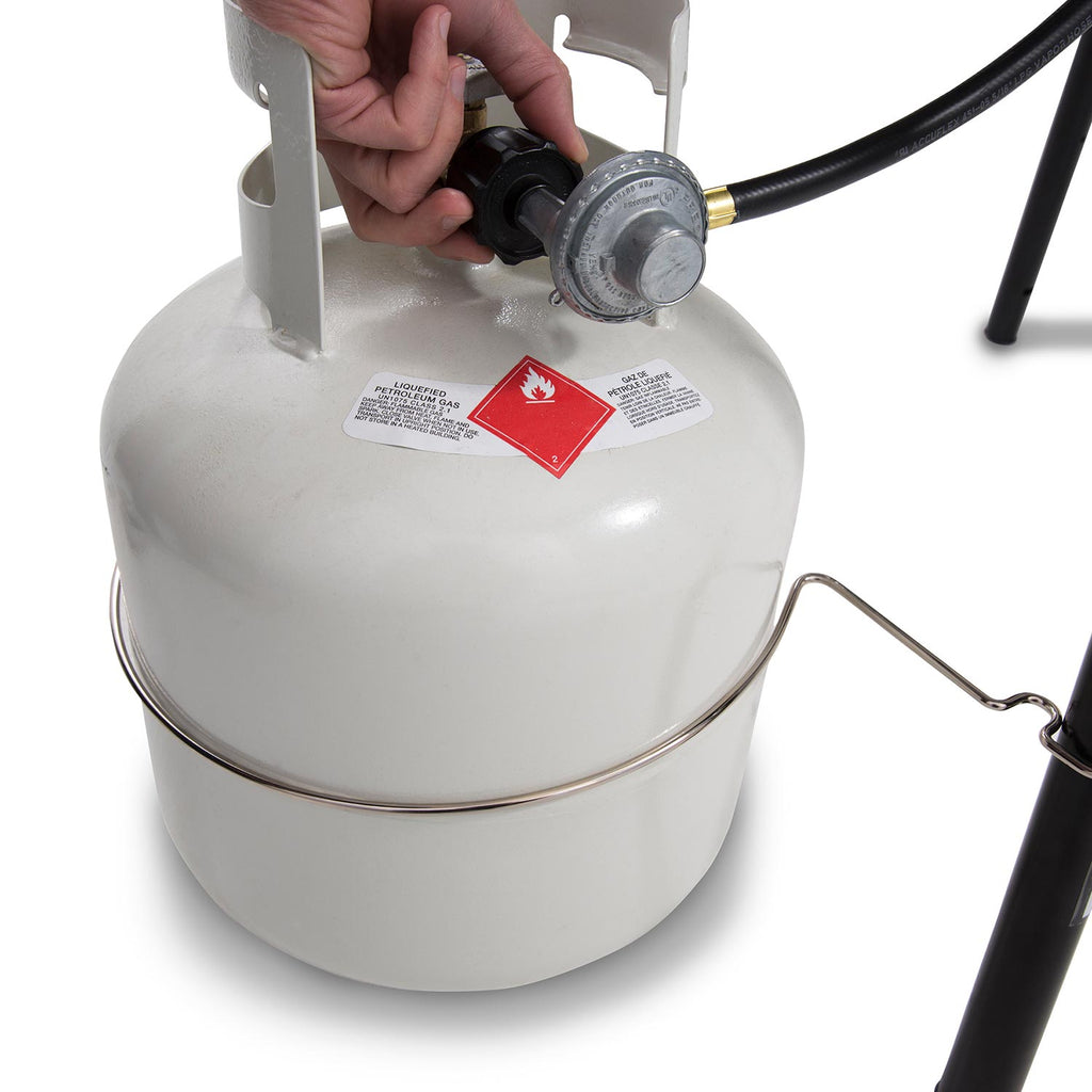 Propane tank regulator with hose connected to a portable propane grill