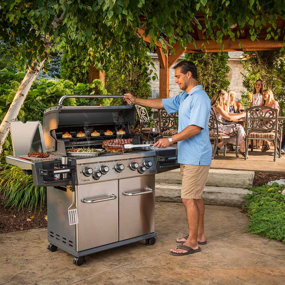 Stainless steel freestanding gas grill with open cooking hood and control knobs