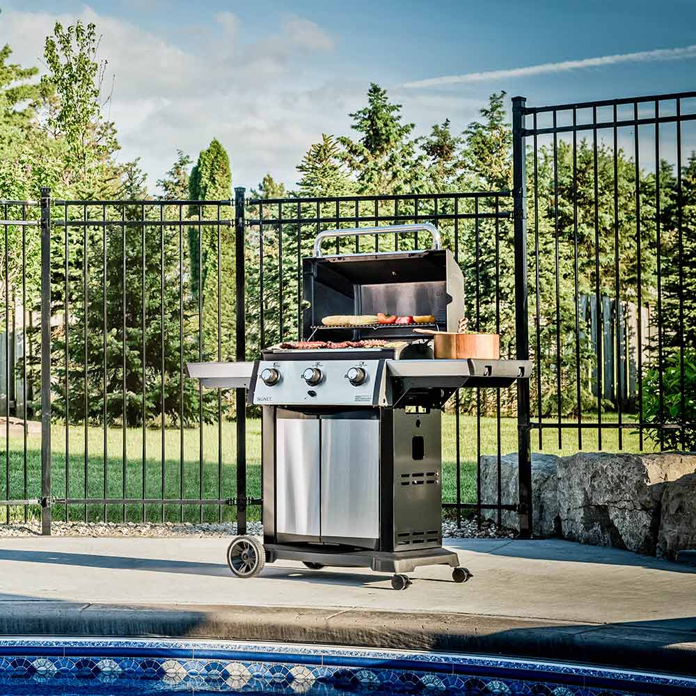 Three-burner gas grill on cart with side shelves and closed lid