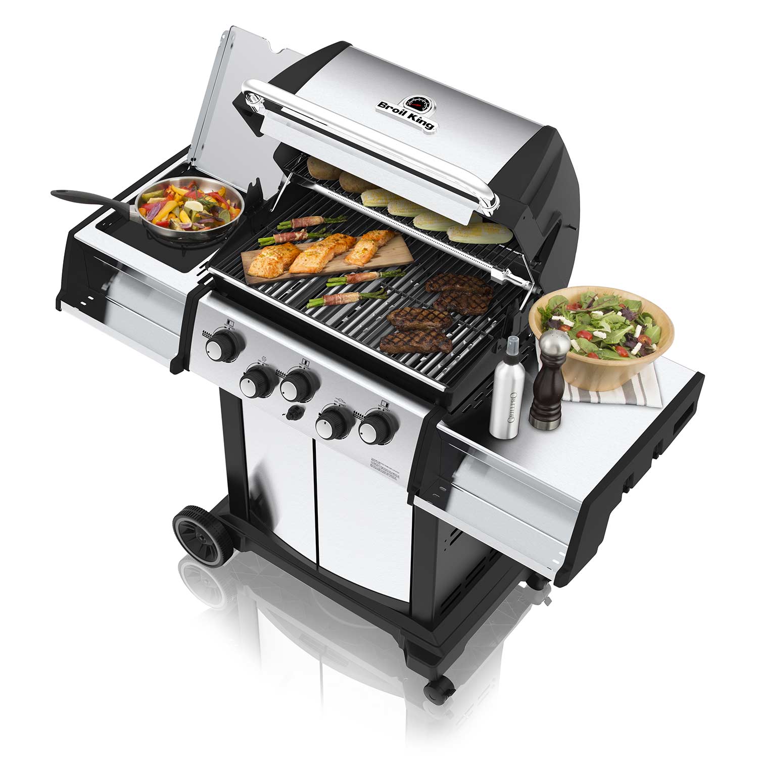 Gas grill with lid open and food cooking on grates, side shelf and utensils