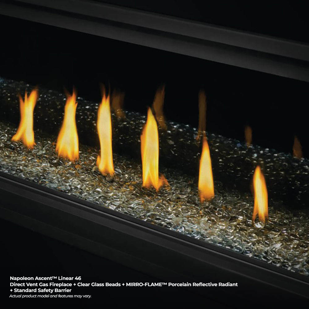 Linear direct-vent fireplace with multiple tall flames over dark pebble bed