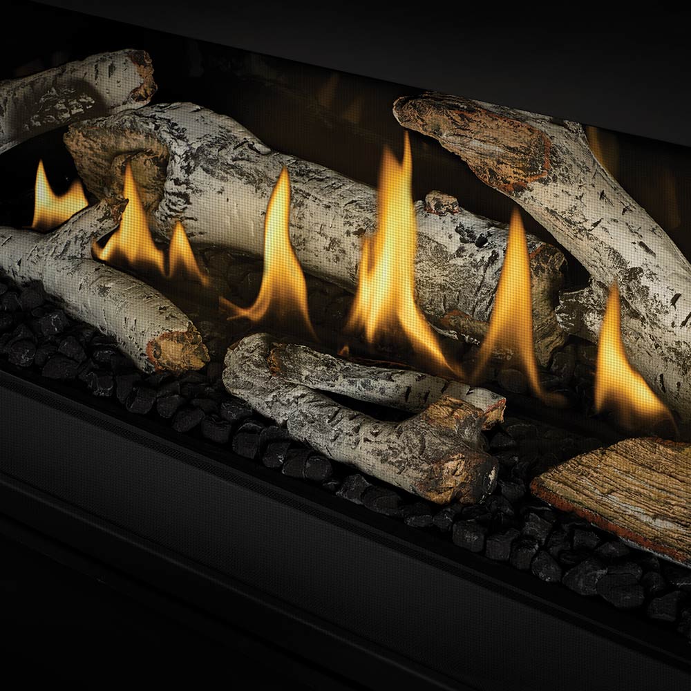 Direct vent gas fireplace burner with gray logs, yellow flames, and black stone bed