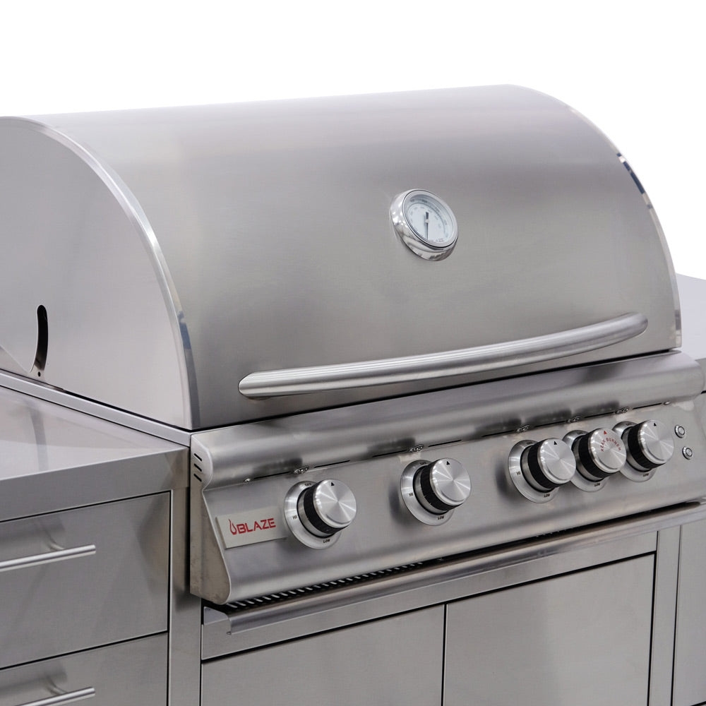 Stainless steel gas grill control panel with multiple knobs and red brand logo