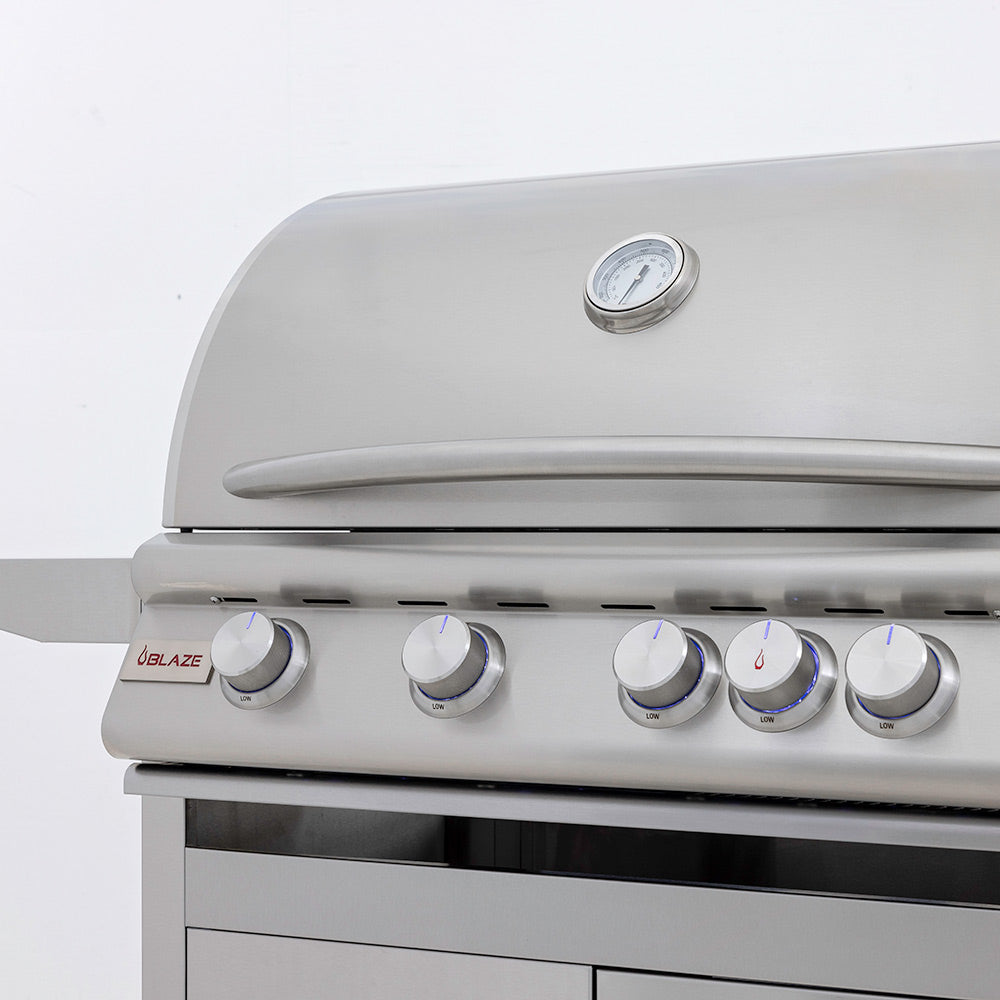 Stainless gas grill control panel with multiple round knobs and temperature gauge