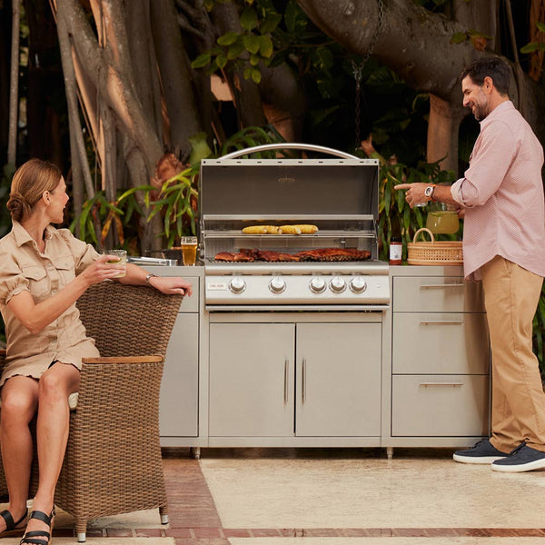 Built-in gas grill with open lid and food cooking on the grill grate
