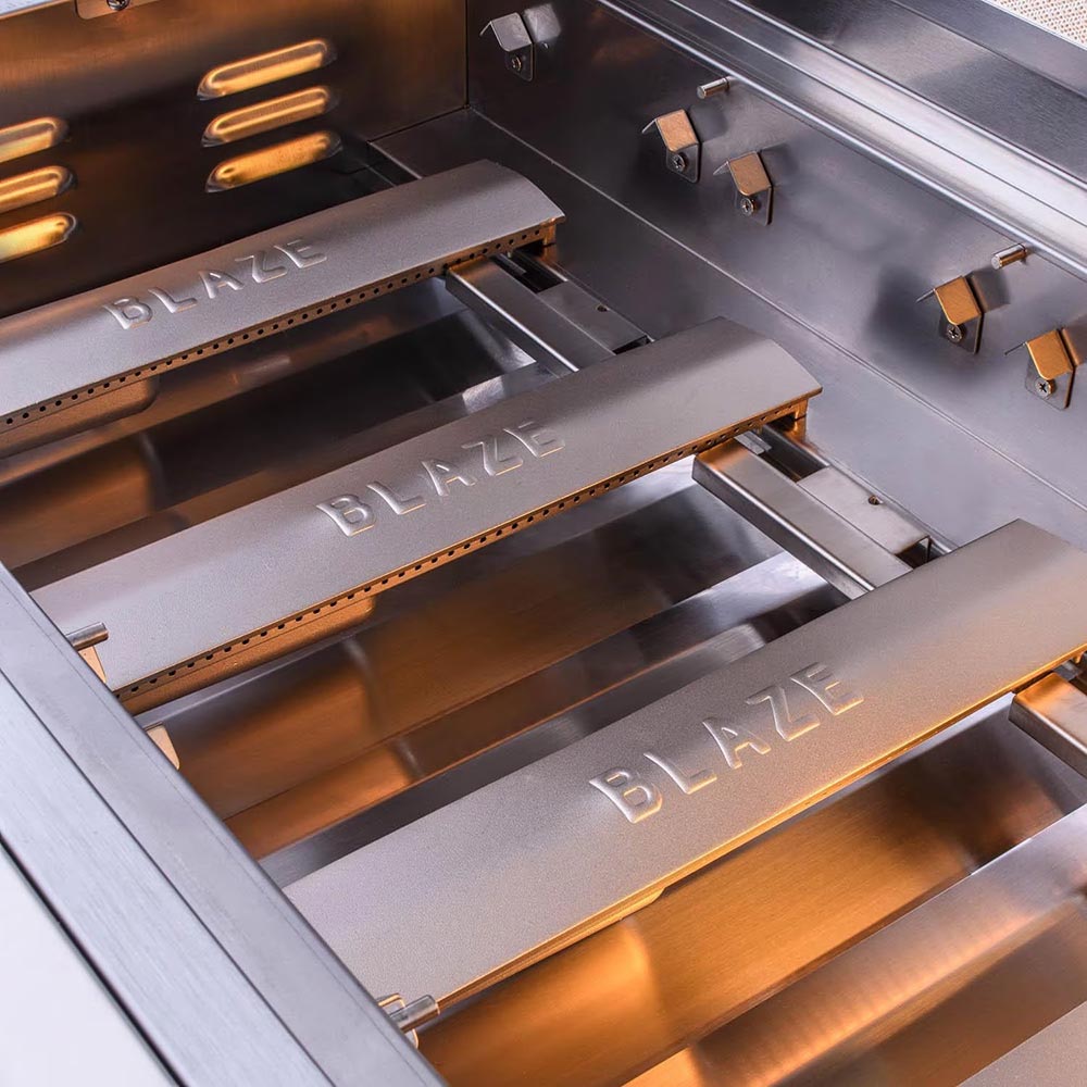 Gas grill interior with stainless steel firebox, grates, and burner assembly visible