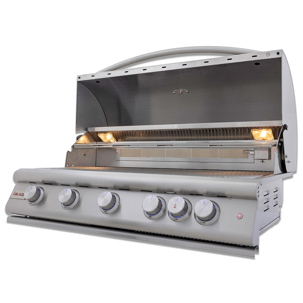 Built-in gas grill with open hood, glowing burner lights, and stainless control panel.