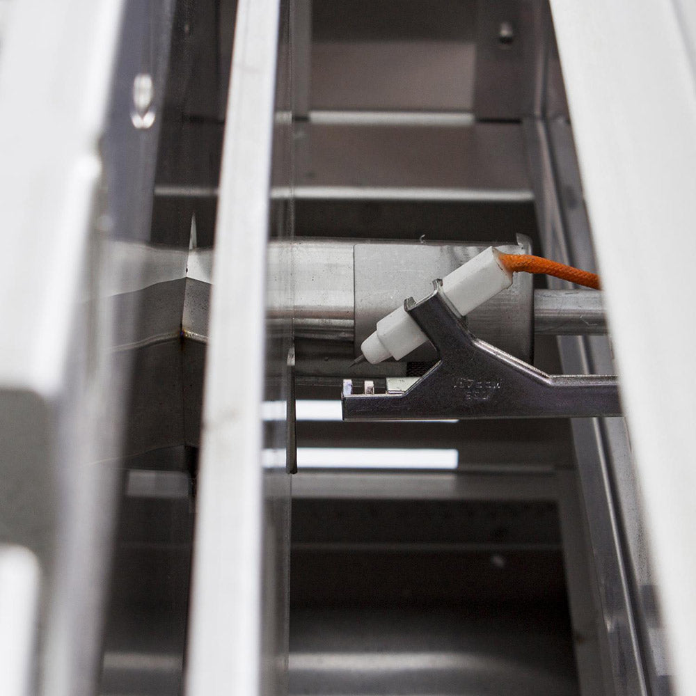 Built-in gas griddle interior showing burner parts and ignition components