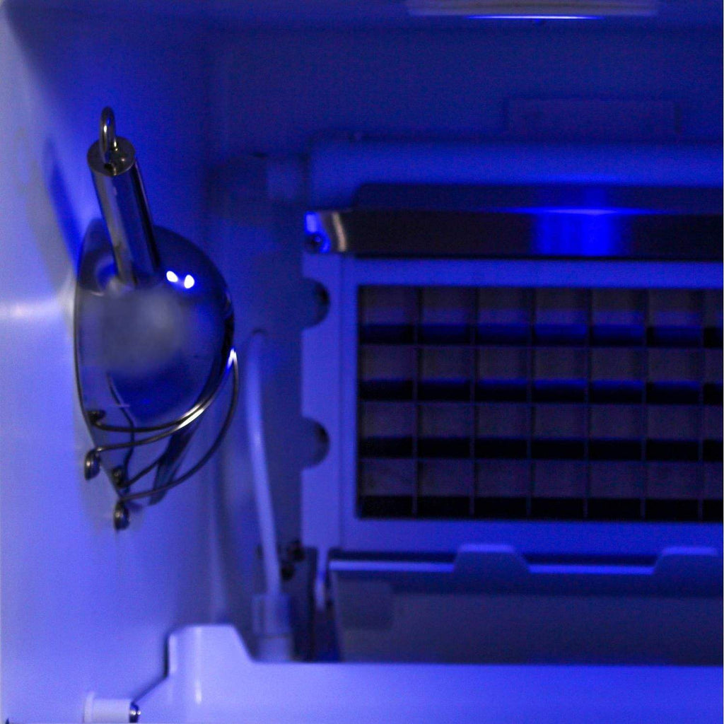 Stainless drain faucet and connected tubing inside the ice maker cabinet