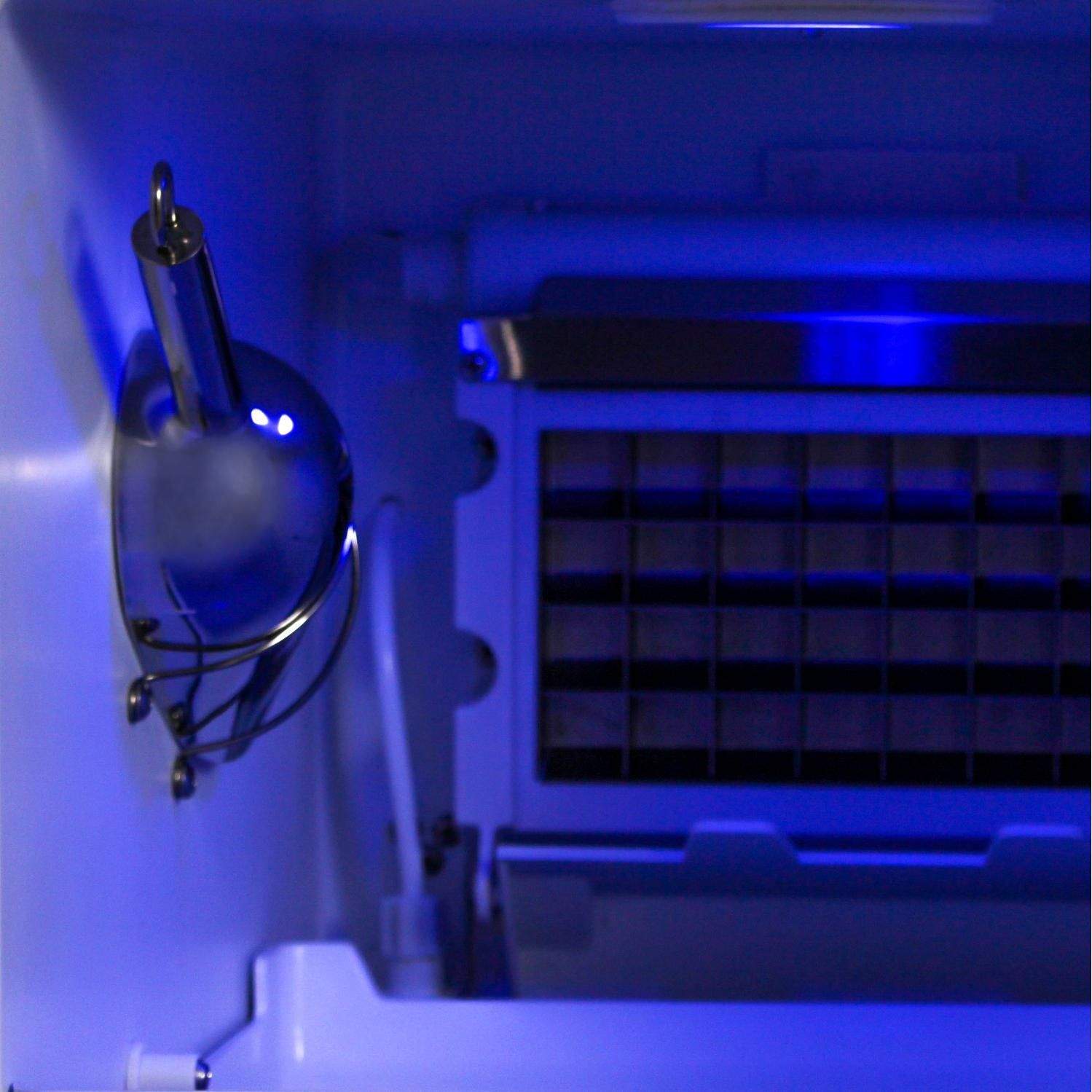 Stainless drain faucet and connected tubing inside the ice maker cabinet