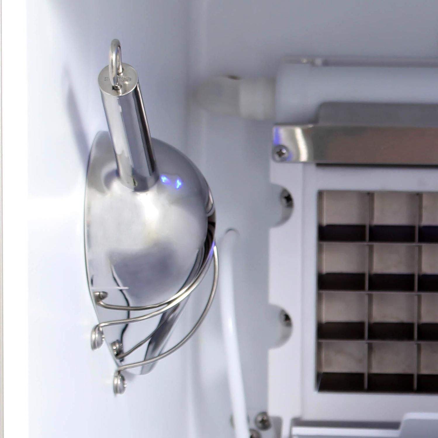 Stainless drain faucet and ice tray area inside the ice maker cabinet